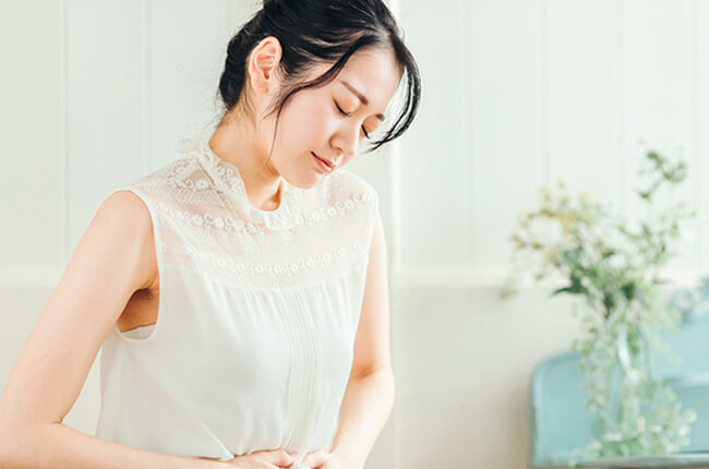 お腹を押さえている女性